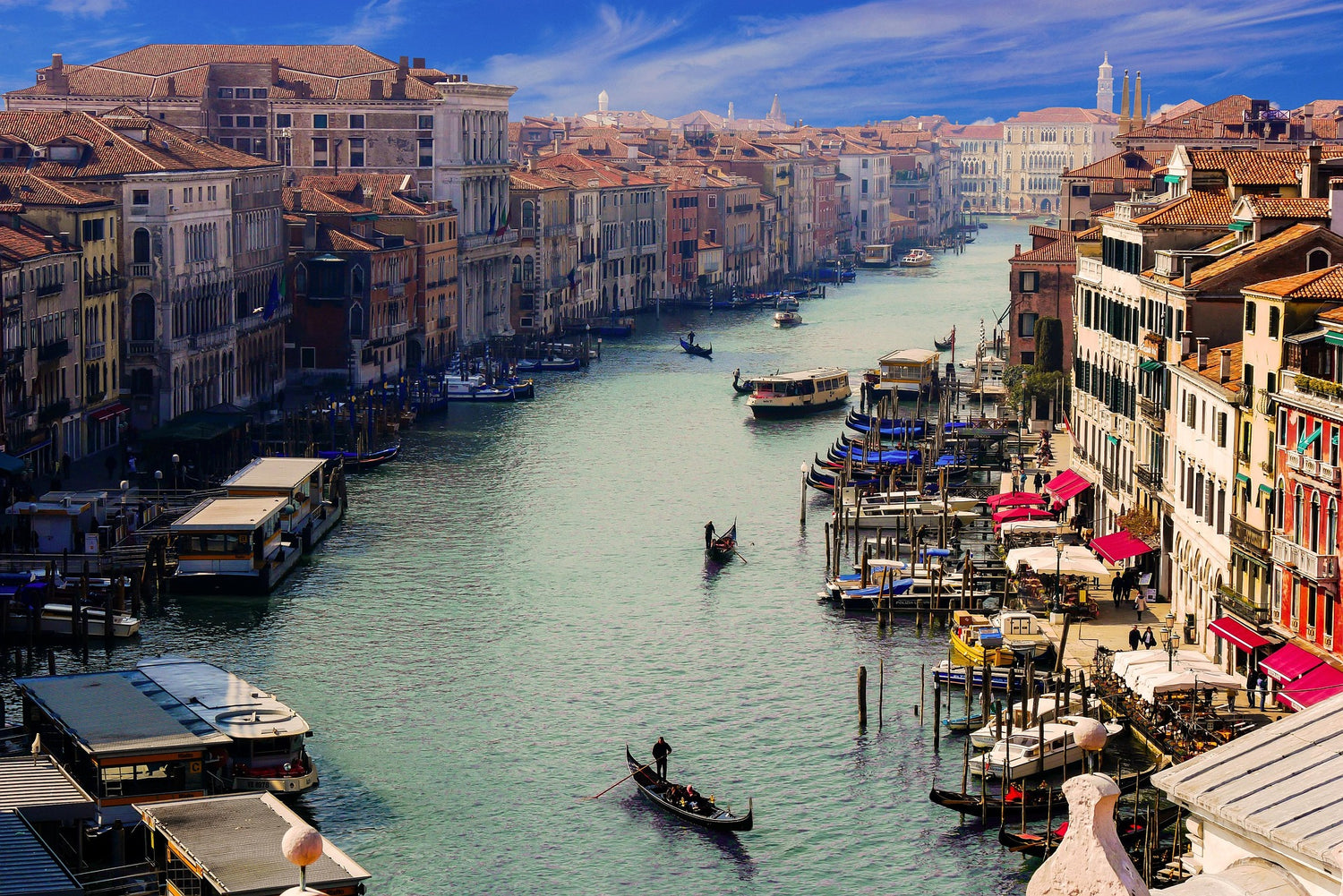 Veduta del Canal Grande a Venezia con gondole e palazzi storici, simbolo dell’eleganza italiana e delle destinazioni servite da Swish & Click.